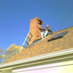 Workers working on maintaining a home chimney