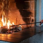 Fireplace with a female hand straightening logs