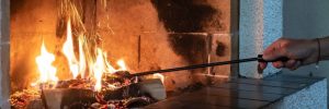 Fireplace with a female hand straightening logs
