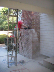 Worker blasting chimney bricks